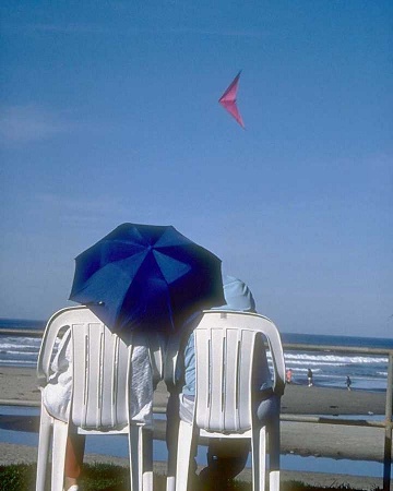 A couple sitting in beach chairs on the beach